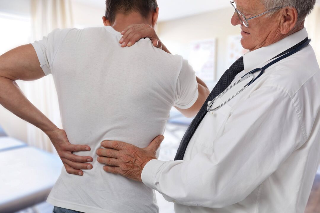 zdravnik, ki pregleda bolnika z bolečinami v hrbtu