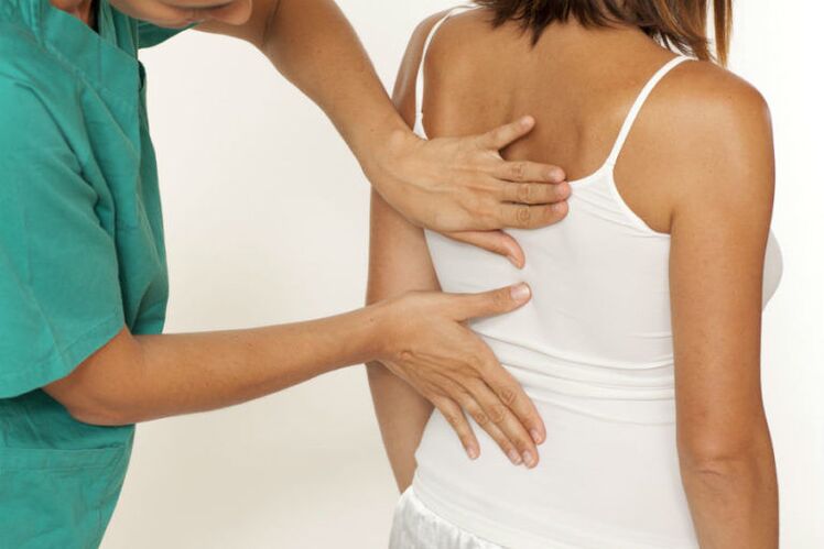zdravnik pregleda hrbet z bolečino pod levo lopatico